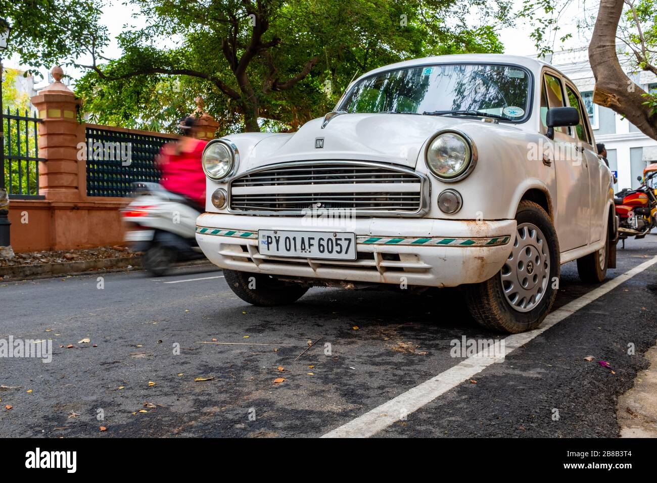 Pondicherry, India - 17 marzo 2018: Auto indiana bianca d'epoca (Ambasciatore Hindustan) e uno scooter che passa con sfocatura motoria Foto Stock