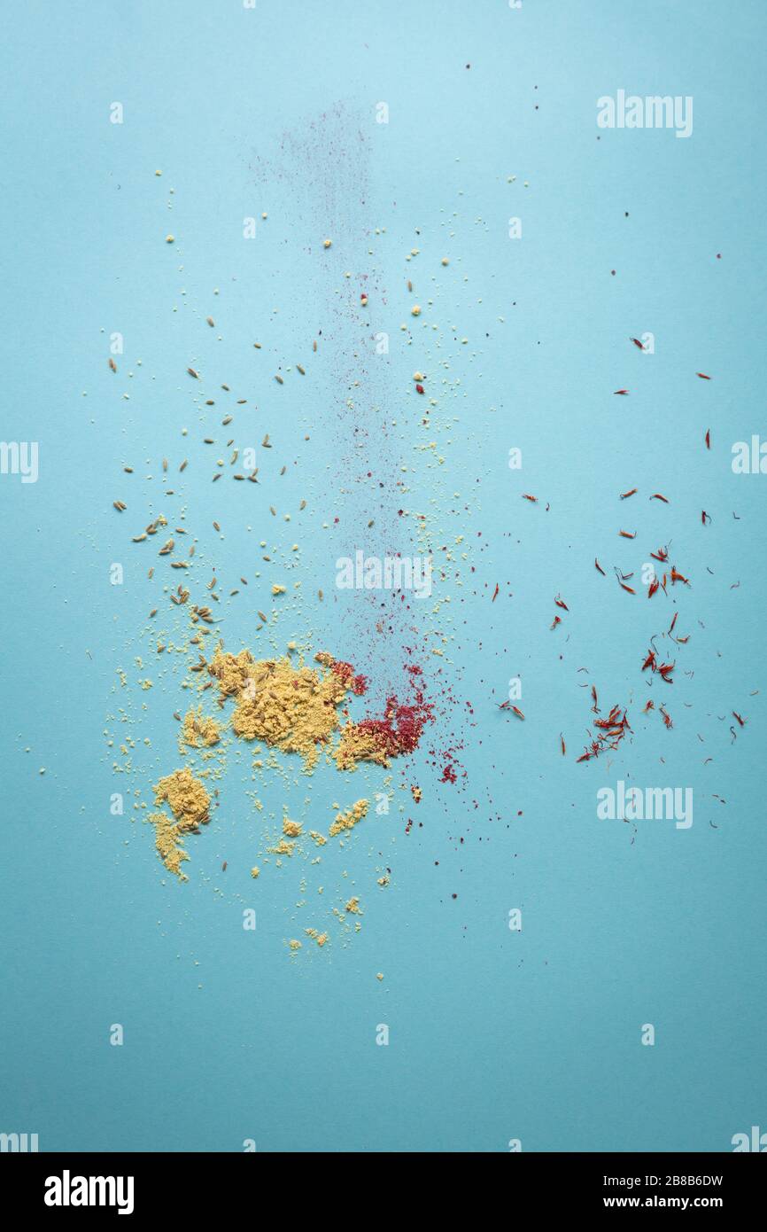 Polvere di spezie su superficie blu chiaro Foto Stock