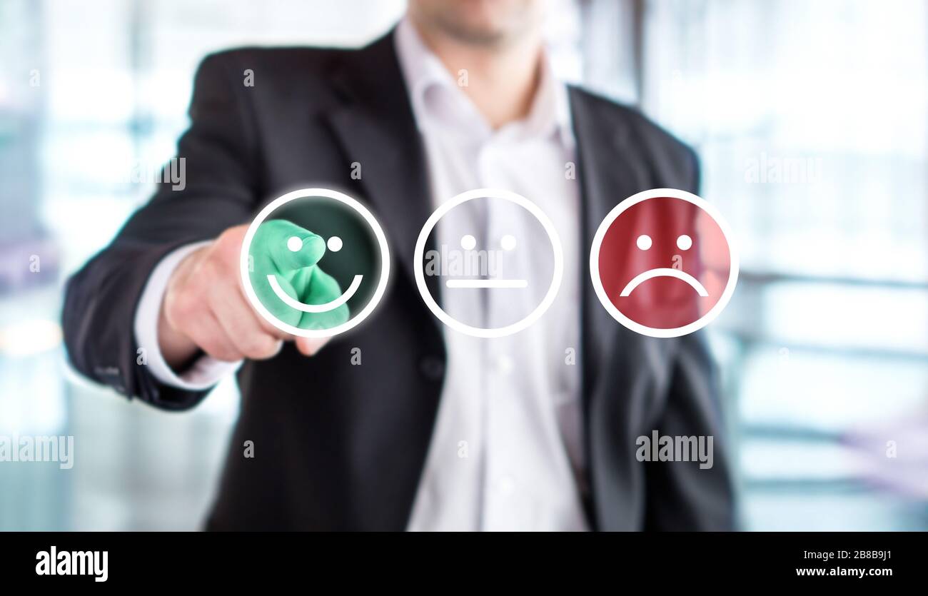Uomo d'affari che dà valutazione e revisione con felice emoticon facciali smiley. Soddisfazione del cliente e sondaggio o sondaggio sulla qualità del servizio o del prodotto. Foto Stock