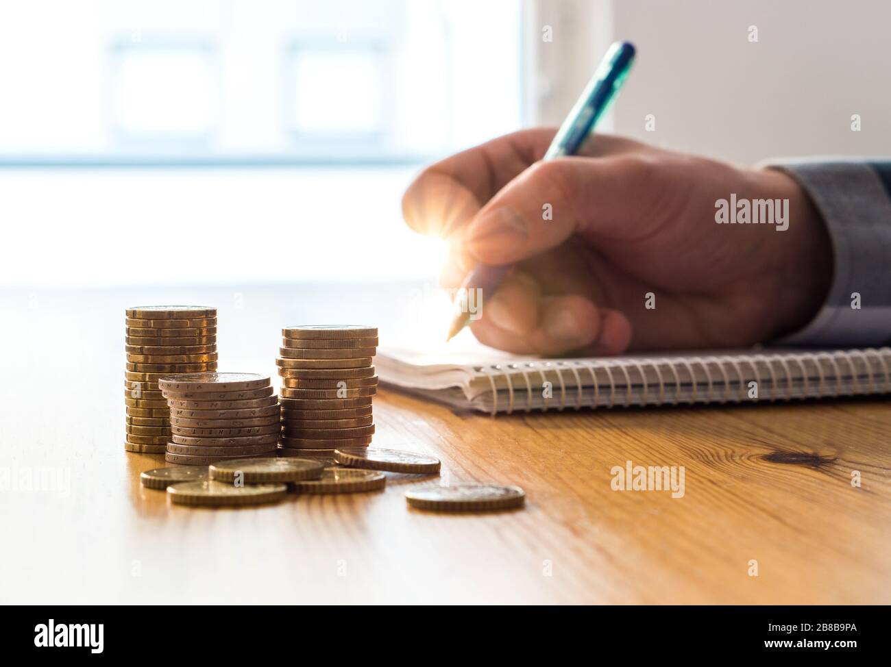 Uomo che conta spese, budget e risparmi e scrivere note su carta con penna. Budget e calcolo del costo della vita familiare. Foto Stock