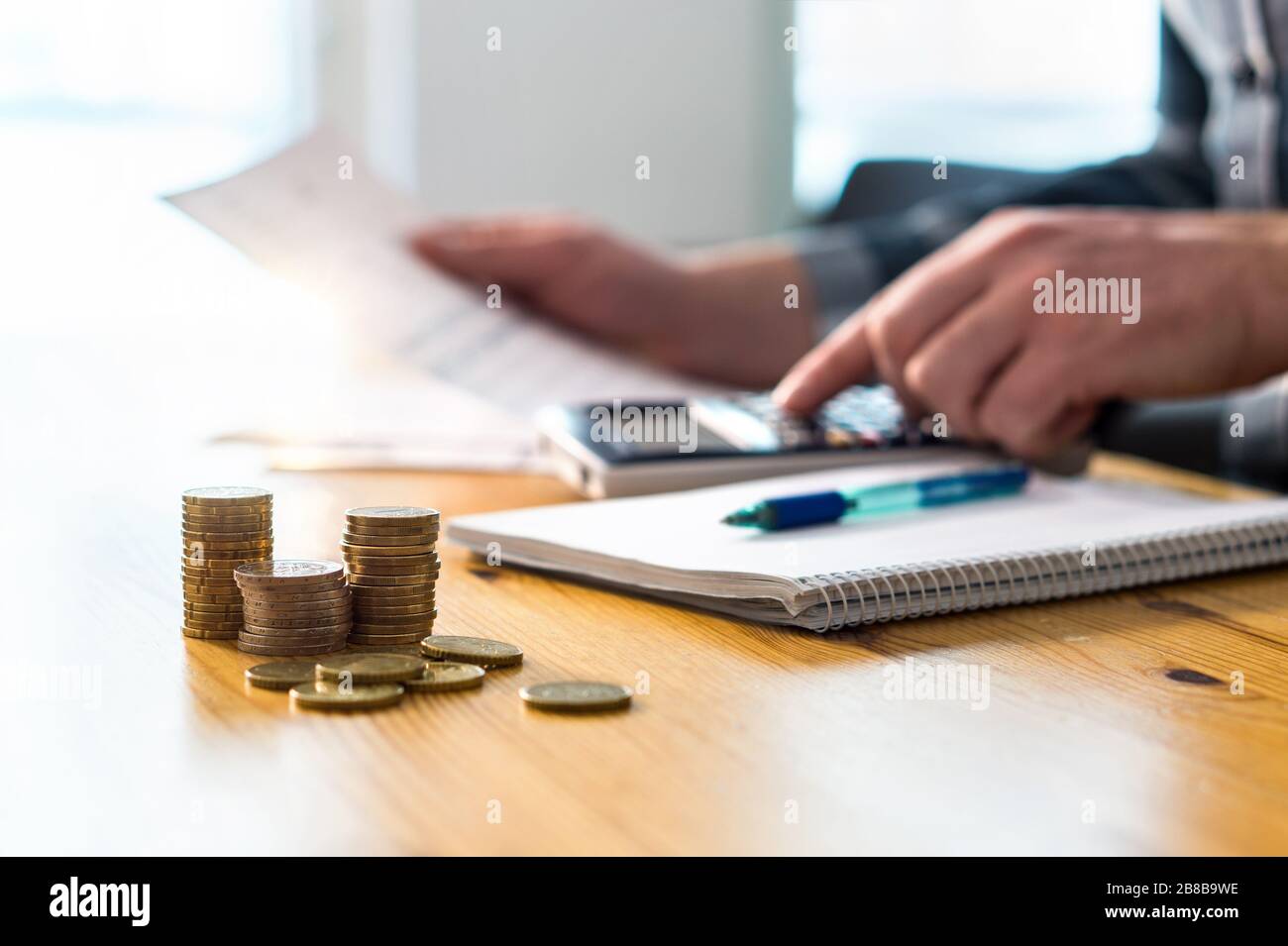 Uomo che usa la calcolatrice e la lettura di documenti finanziari. Imprenditore, contabile o contabile che lavora e conta tasse, iva, prestito, debito o risparmio. Foto Stock