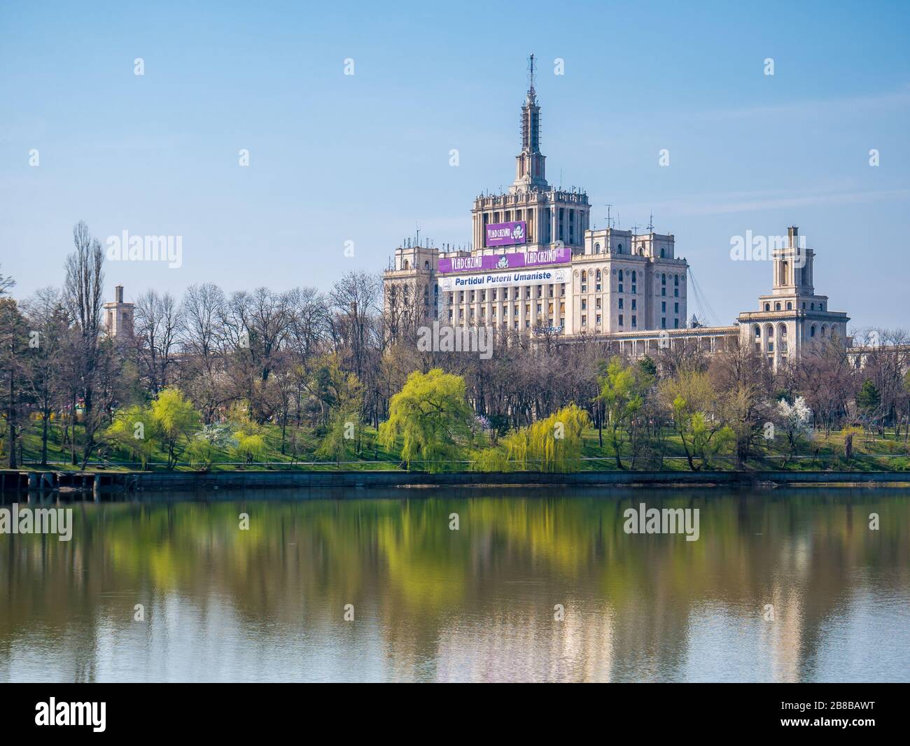 Bucarest/Romania - 03.19.2020: La Casa della libera Stampa a Bucarest visto dal Parco Herestrau o dal Parco Re Mihai I. Alberi che riflettono nell'acqua. Foto Stock
