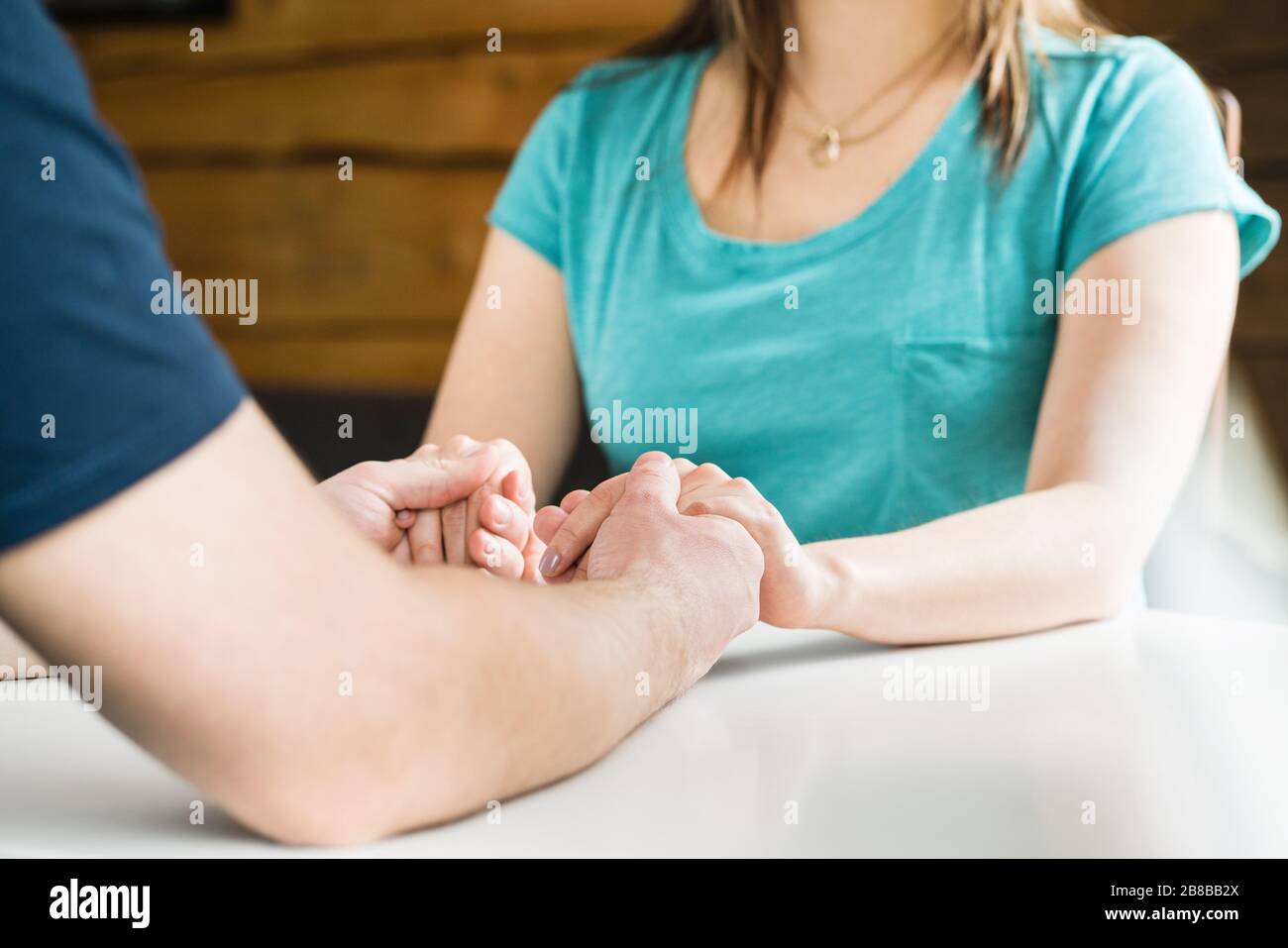Unire le mani sul tavolo. Sostegno, aiuto, cura, perdono o scuse. Uomo donna triste consolante. Compassione ed empatia. Foto Stock
