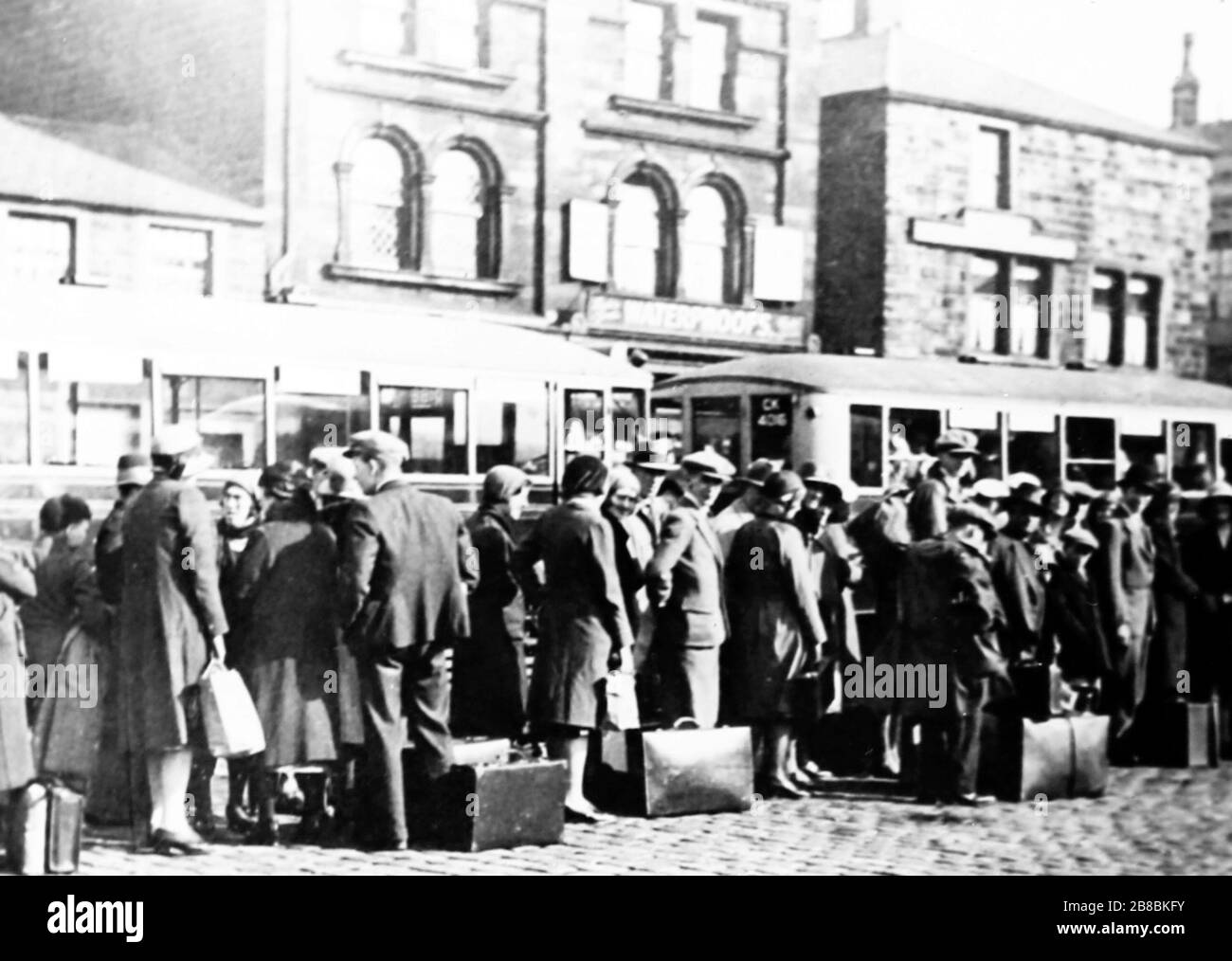 Coda per gli autobus a Burnley, probabilmente sveglia settimana, forse anni '30 Foto Stock