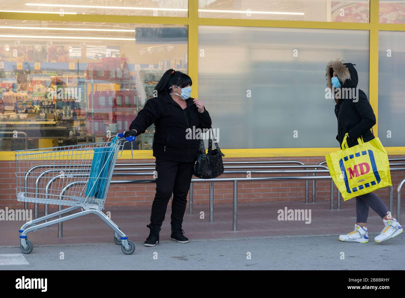 Campobasso,Regione Molise,Italia:due donne con maschere protettive accodano al supermercato mantenendo una distanza di sicurezza durante l'emergenza coronavirus a CA Foto Stock