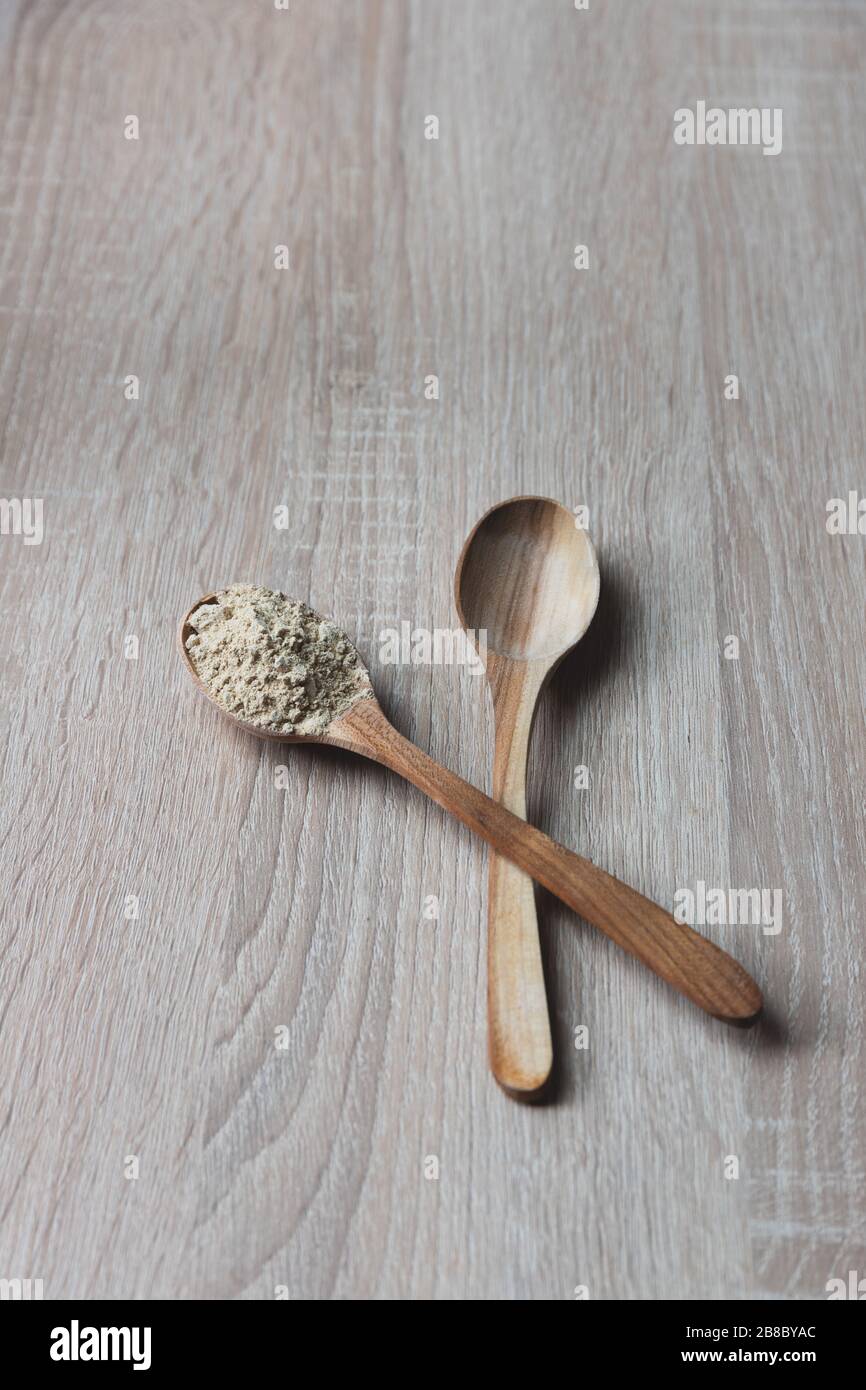 Polvere di radice di Maca in un cucchiaio di legno, cibo eccellente Foto Stock
