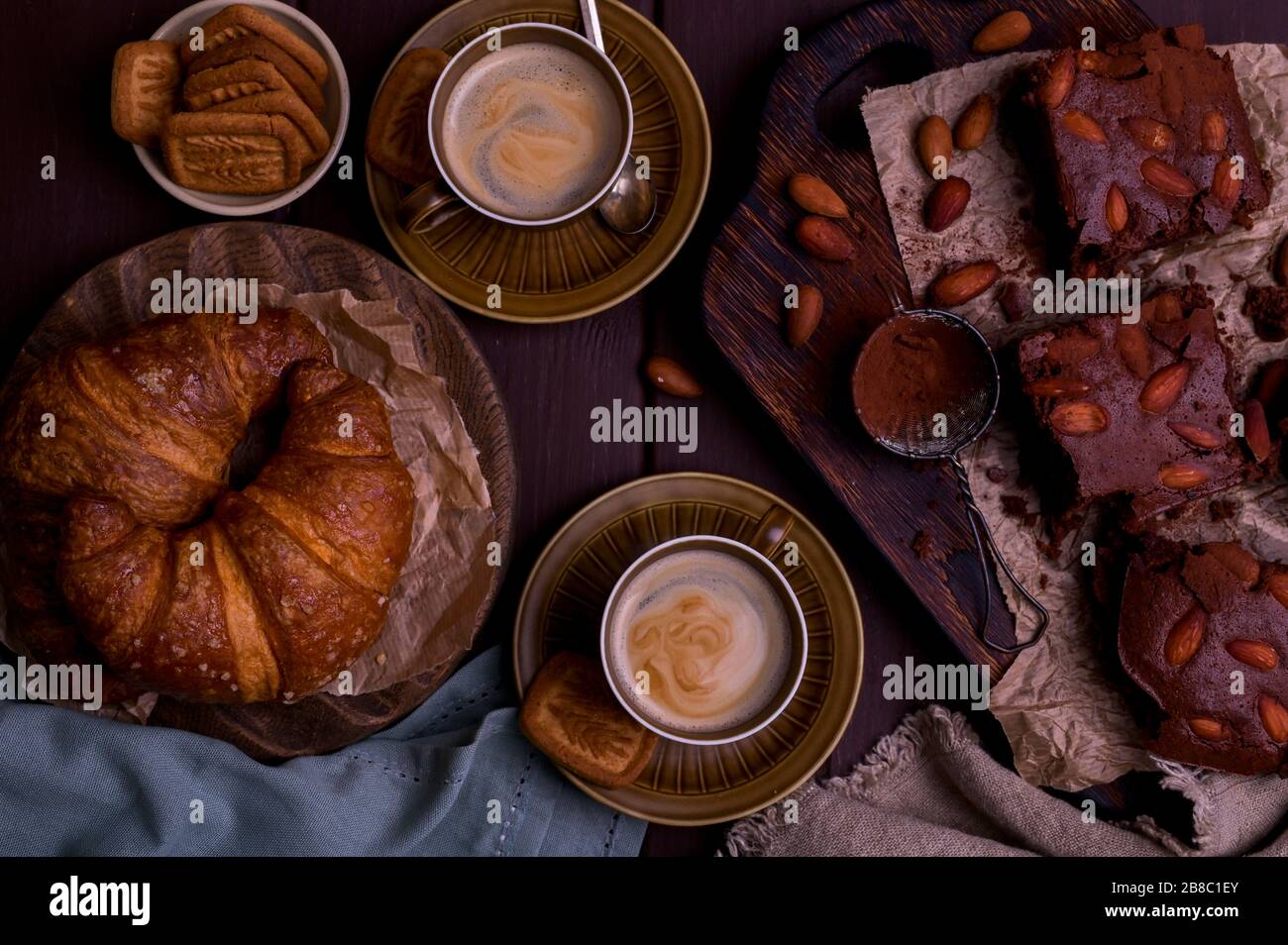 Brownie e croissant per colazione con caffè aromatico. Tradizionale torta americana e espresso italiano. Gustosa colazione vintage. Vista dall'alto. Spazio libero per testo.croissant Vista dall'alto. Foto Stock