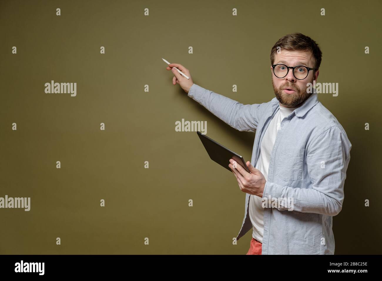 Discussione del progetto. L'uomo concentrato con un tablet in mano racconta la sua idea e mostra con uno stilo sullo spazio di copia. Foto Stock