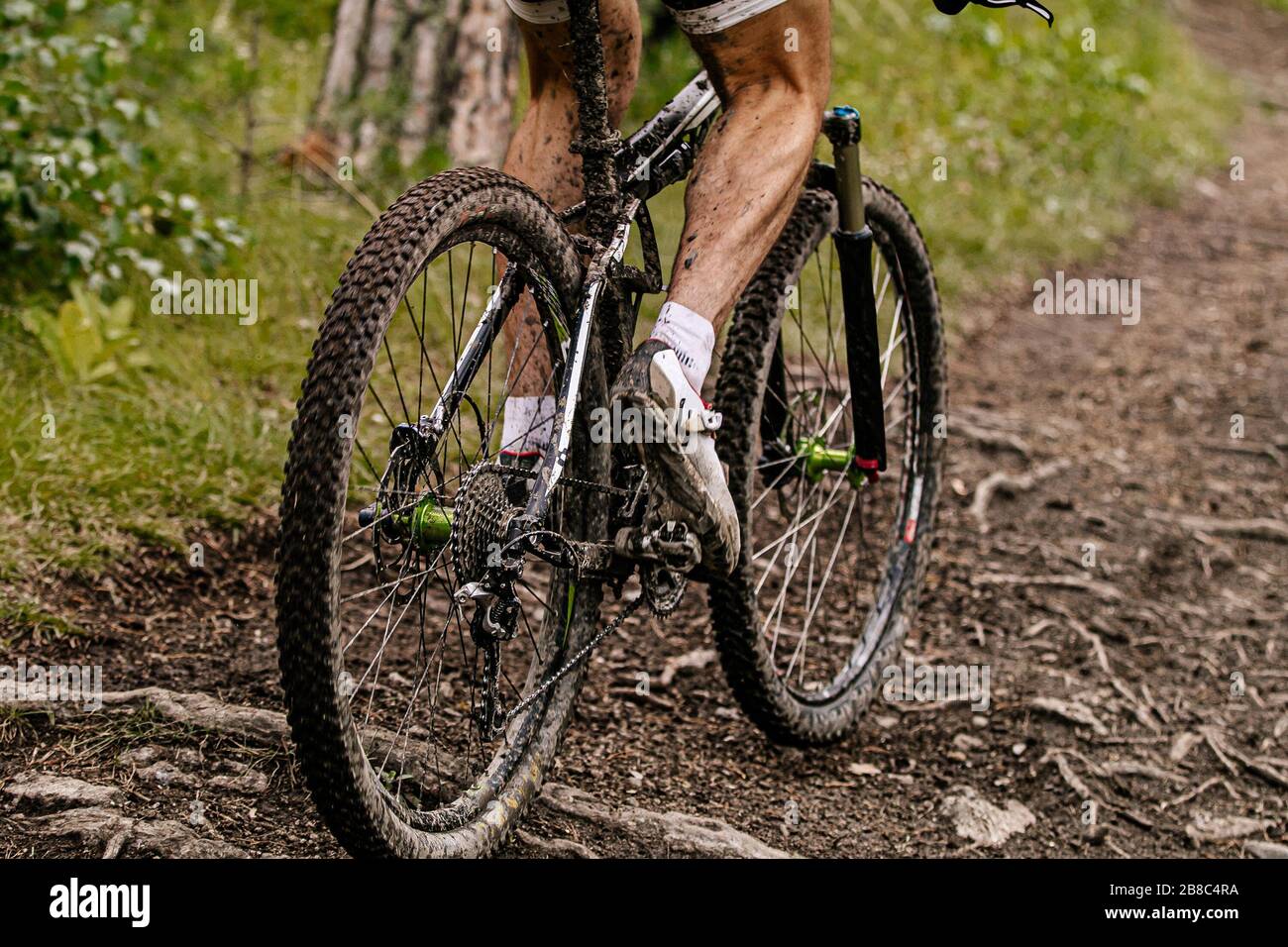 chiudi i piedi sporchi ciclista e mountain bike su sentiero forestale Foto Stock