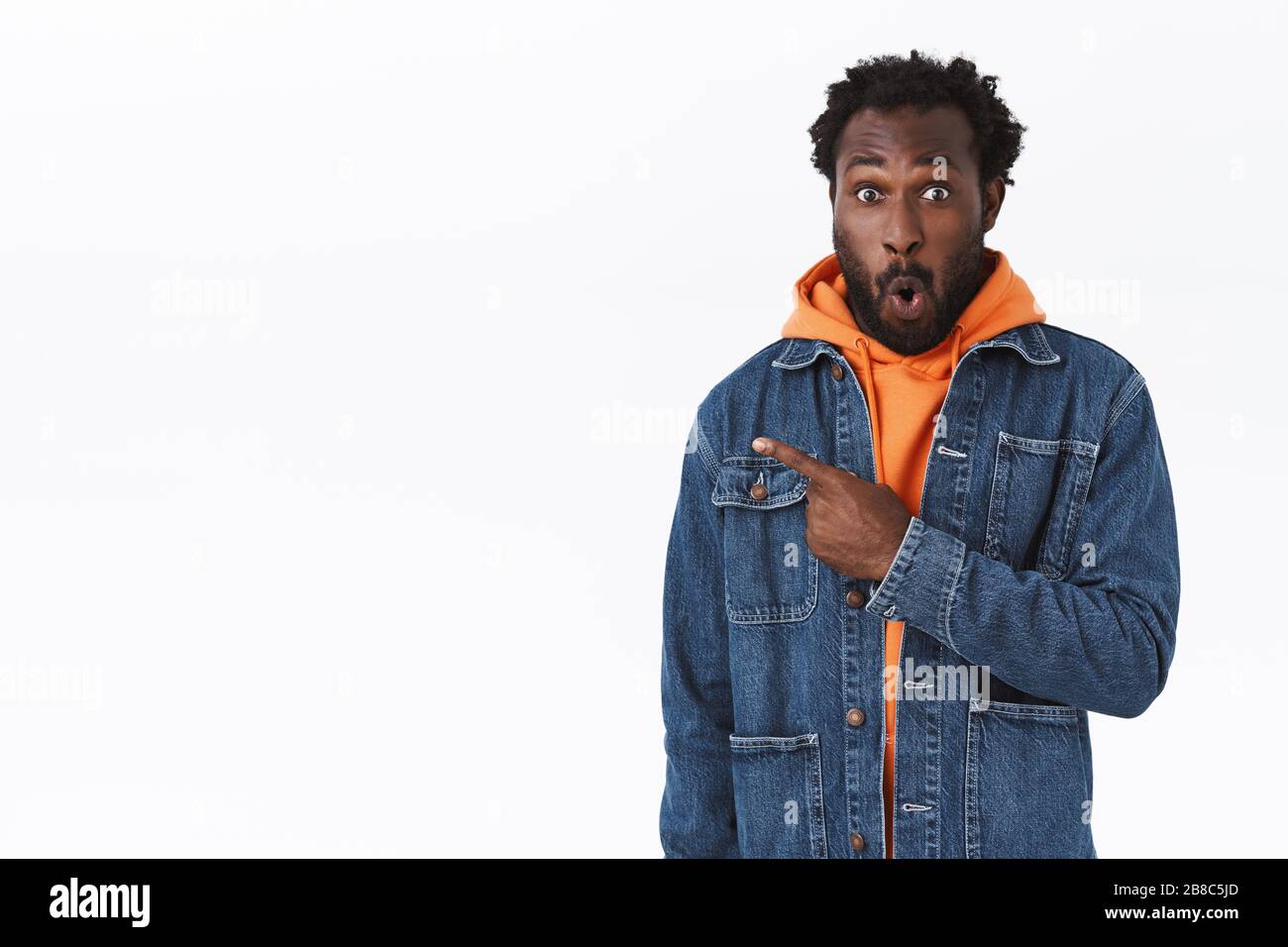 Impressionato stupito afro americano bearded guy in jeans giacca felpa con cappuccio arancione fischio da stupore labbra pieghevoli dire wow entusiasta puntando Foto stock Alamy
