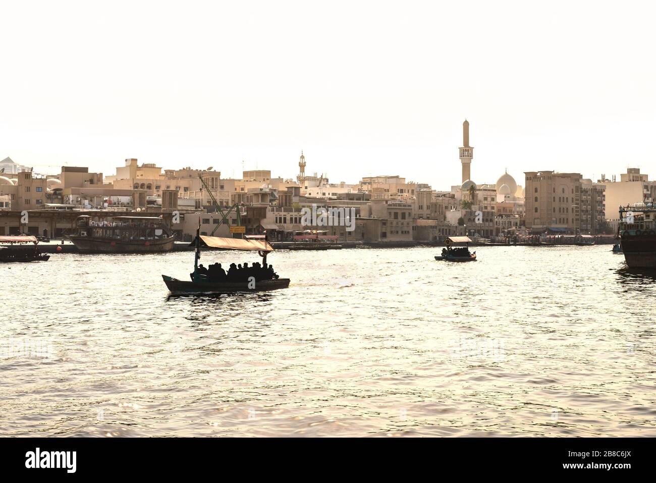 Dubai Creek con barche abra. Persone locali e turisti che utilizzano taxi d'acqua e traghetto nel fiume della città vecchia. Crociera tradizionale. Vista panoramica sulla città araba. Foto Stock