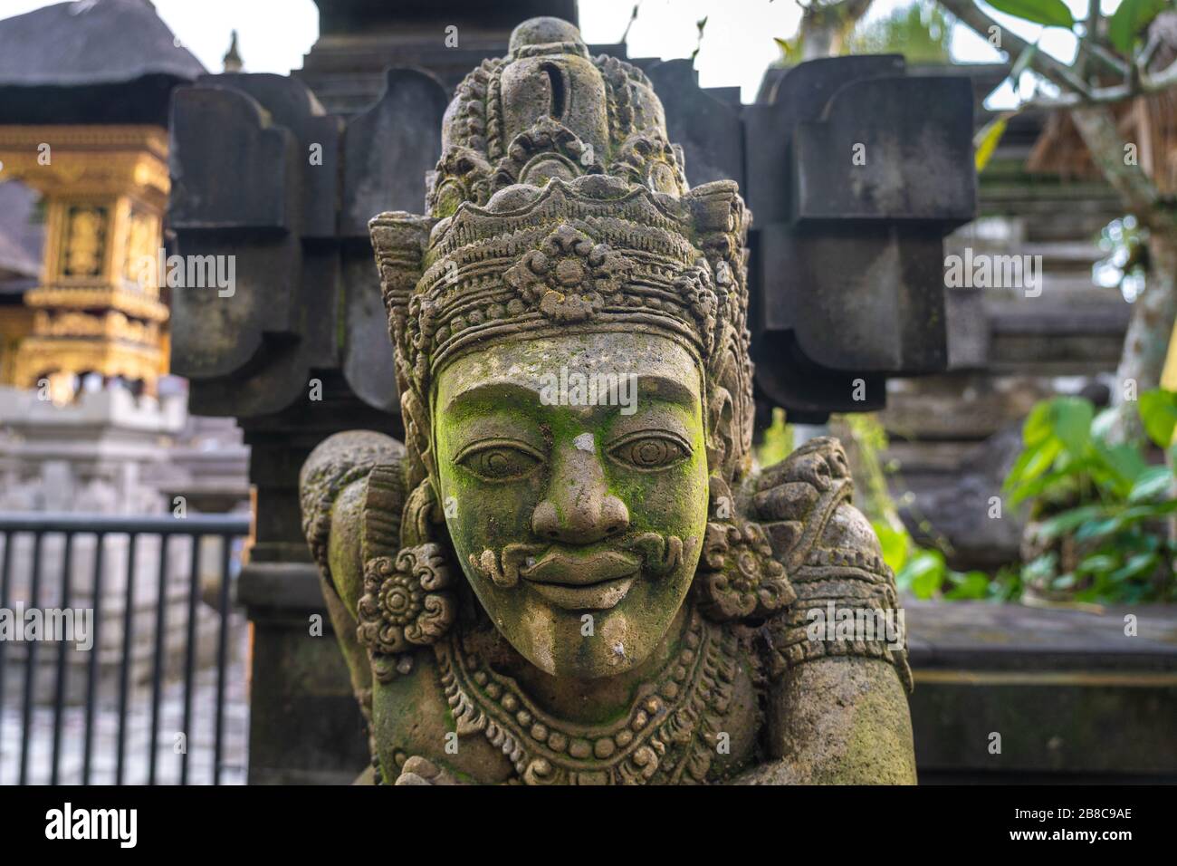 Tradizionale statua balinese di un uomo mitologico con moos nel Tempio di Tirta Empul Foto Stock