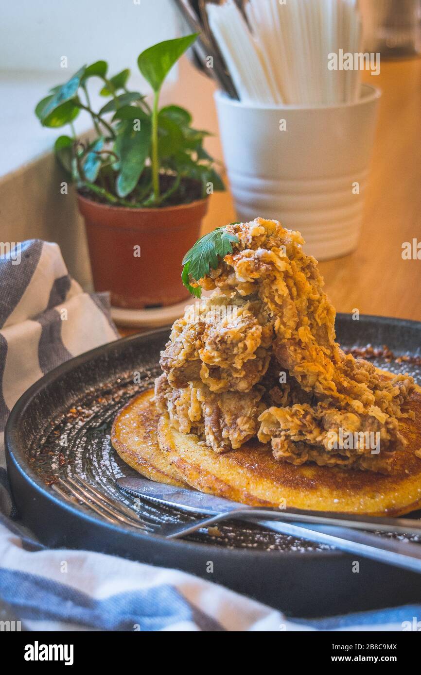 Pollo fritto su pancake di latticello fatti in casa serviti con acero al peperoncino Foto Stock