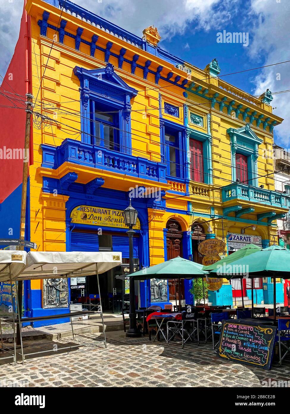 Vecchi edifici colorati; architettura ornata, dipinti con colori vivaci, strade, aziende, ombrelloni, balconi, quartiere la Boca; Sud America, Buenos Aires Foto Stock