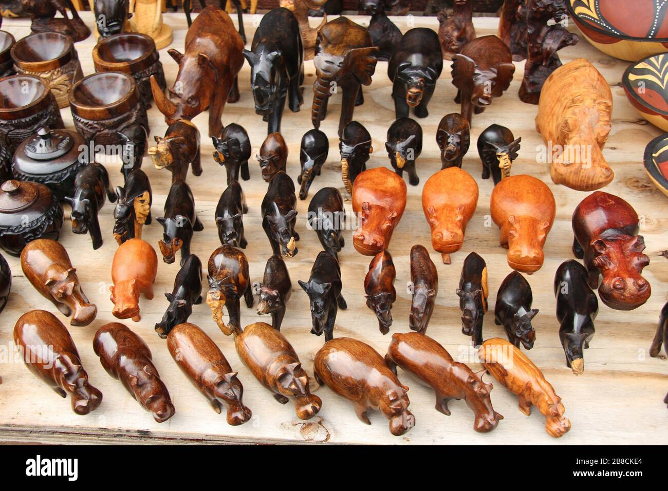 Souvenir africani: Piccole sculture in legno sculture di ippopotami e rinoceronti. Presentato accanto al ponte Bloukrans, Garden Route, Sud Africa. Foto Stock