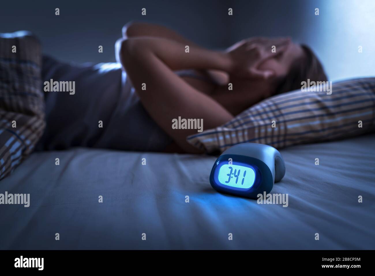 Donna senza sonno che soffre di insonnia, apnea del sonno o stress. Signora stanca ed esausta. Mal di testa o emicrania. Svegliati nel bel mezzo della notte. Foto Stock