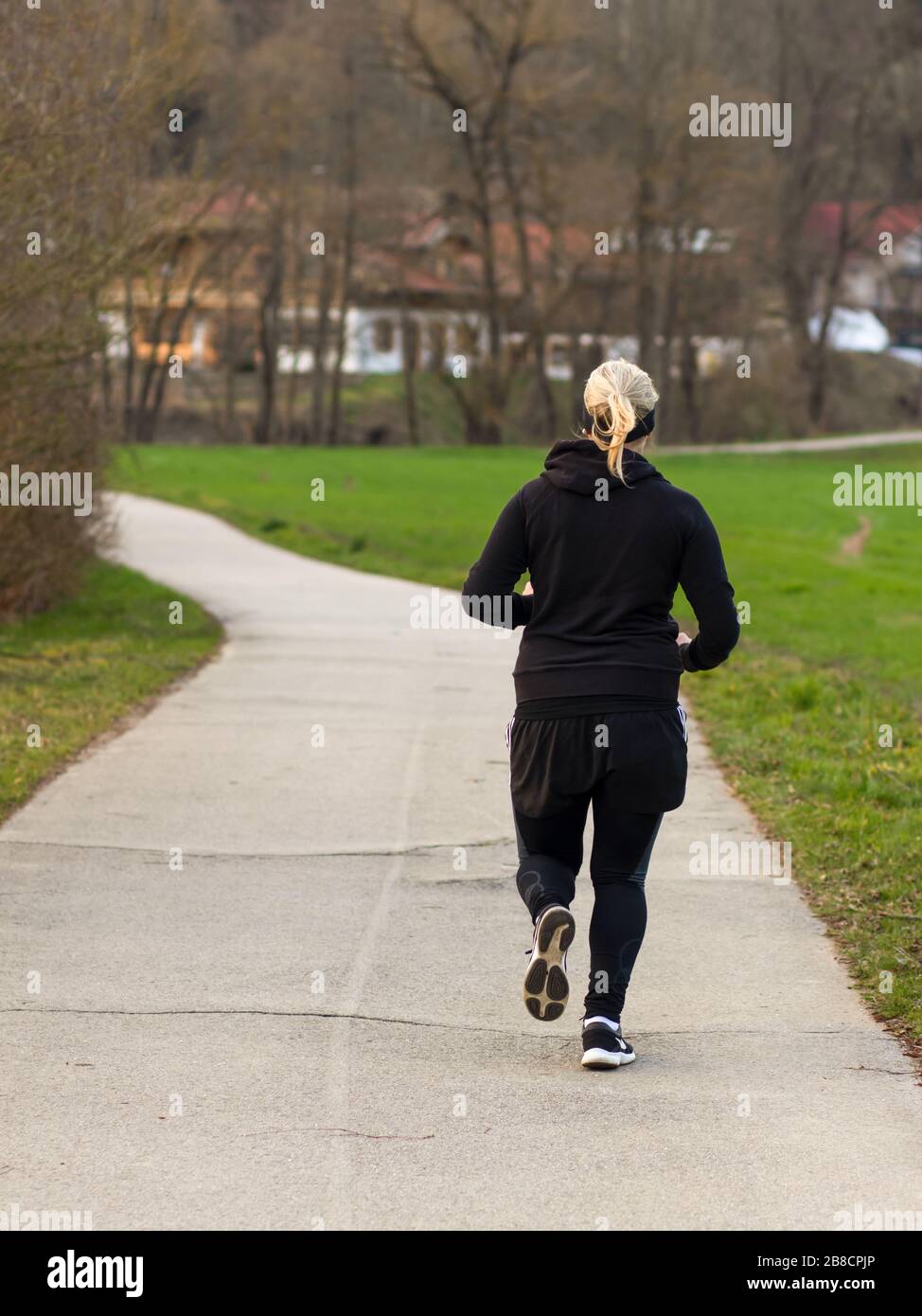 Giovane donna che corre in un parco Foto Stock