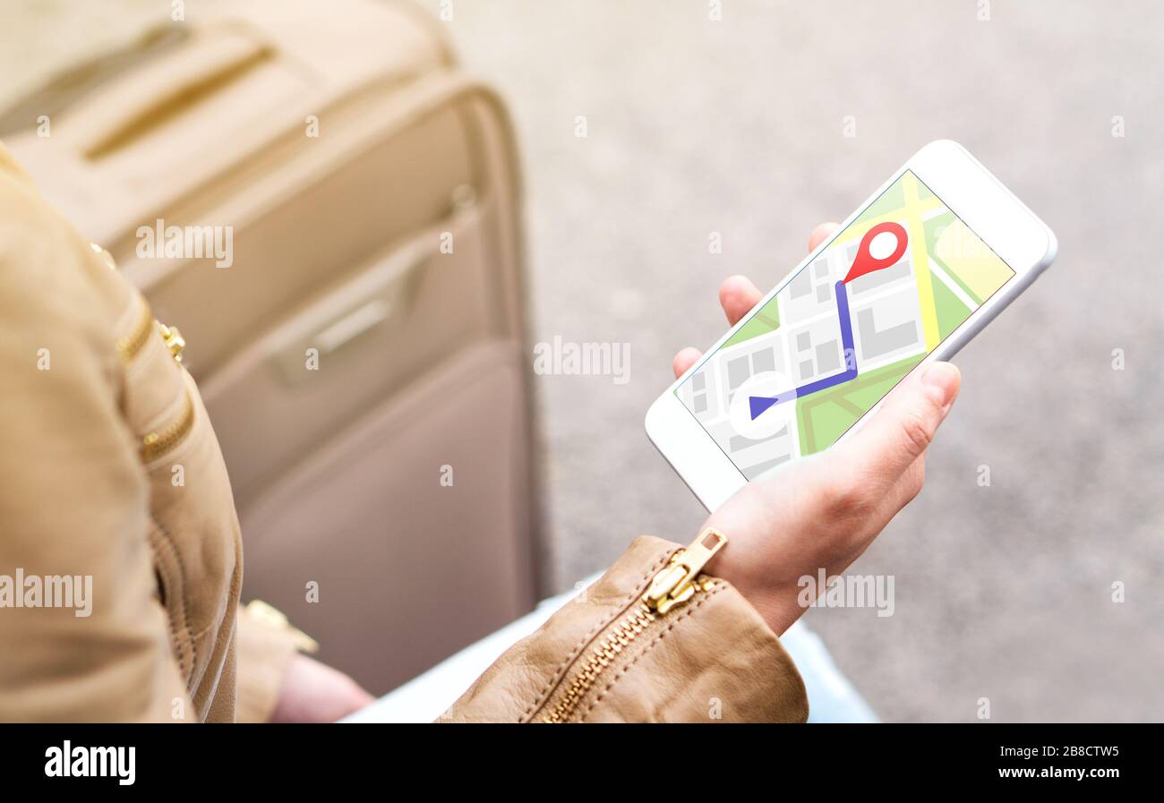 Tourist utilizza la mappa nell'app telefonica per navigare e trovare la posizione dell'hotel in città. Donna con smartphone e bagagli che utilizza il servizio GPS. Foto Stock