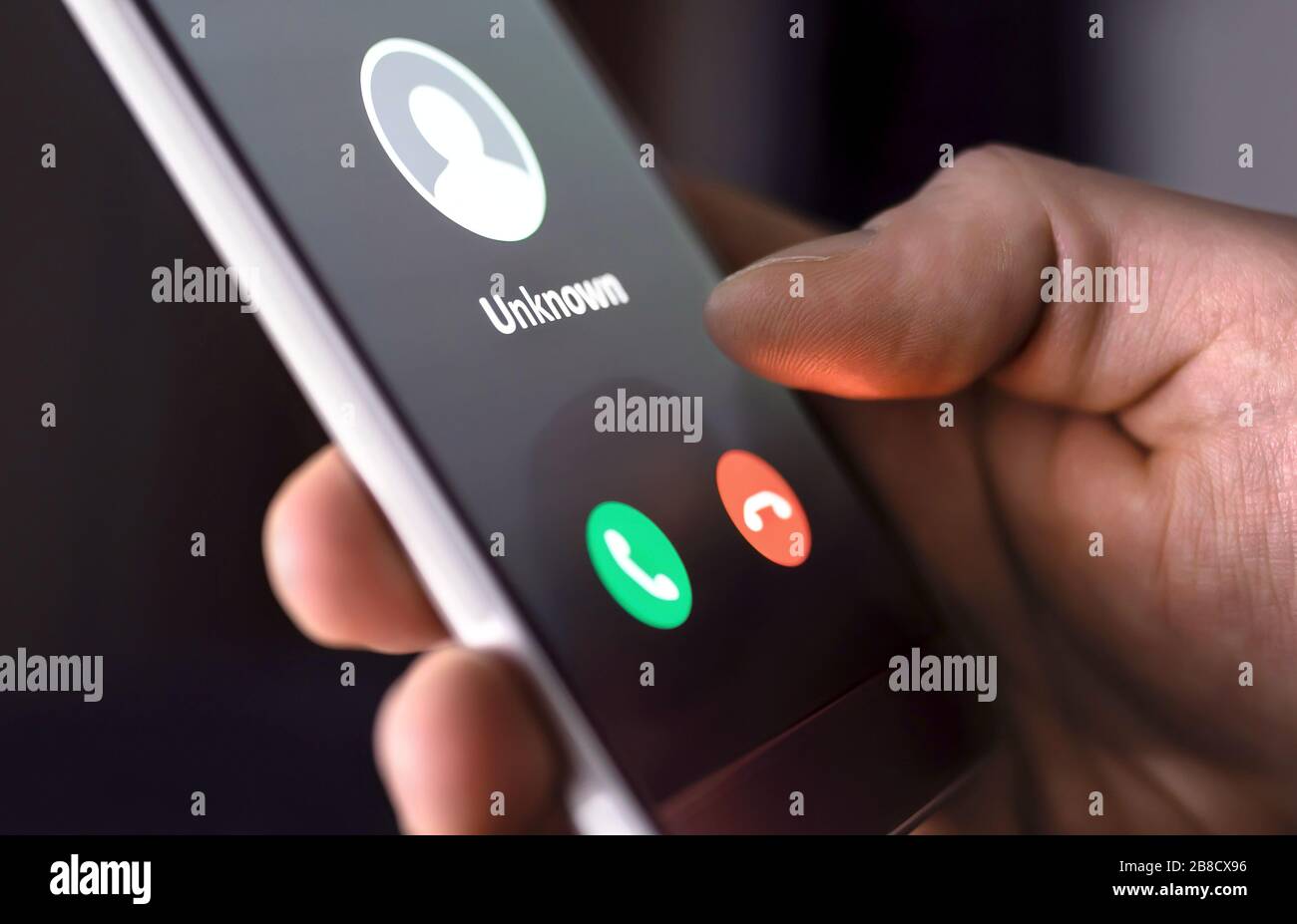 Chiamata telefonica da un numero sconosciuto a tarda notte. Truffa, frode o phishing con il concetto di smartphone. Scaldati il chiamante, lo scammer o lo sconosciuto. Uomo che risponde. Foto Stock