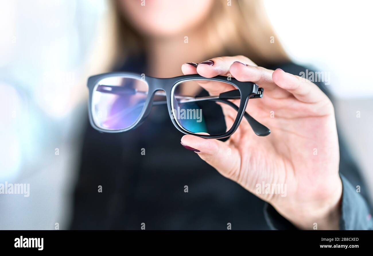 Ottico, ottometristo, oculista o medico oculista tenere occhiali e specifiche con nuove lenti. Specialista professionale della vista in clinica o in negozio. Foto Stock