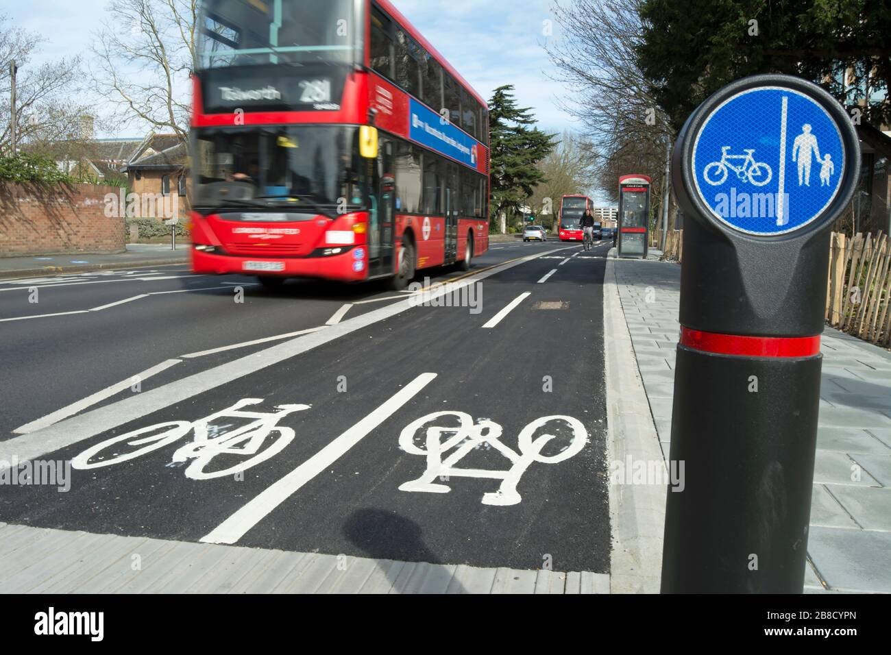 pista ciclabile a kingston upon thames, surrey, inghilterra, con autobus di passaggio visto in movimento sfocato e corsie separate per pedoni e ciclisti segno Foto Stock