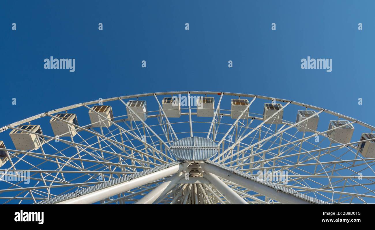 Vista dal basso della struttura metallica della ruota ferris su sfondo blu brillante Foto Stock