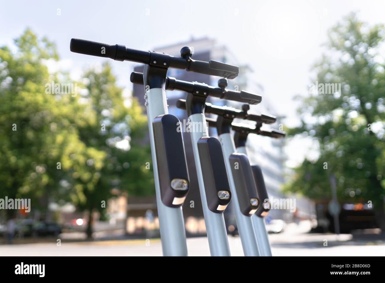 Molti scooter elettrici parcheggiati in città. E veicolo a noleggio. Trasporto urbano moderno e concetto di tecnologia. Foto Stock
