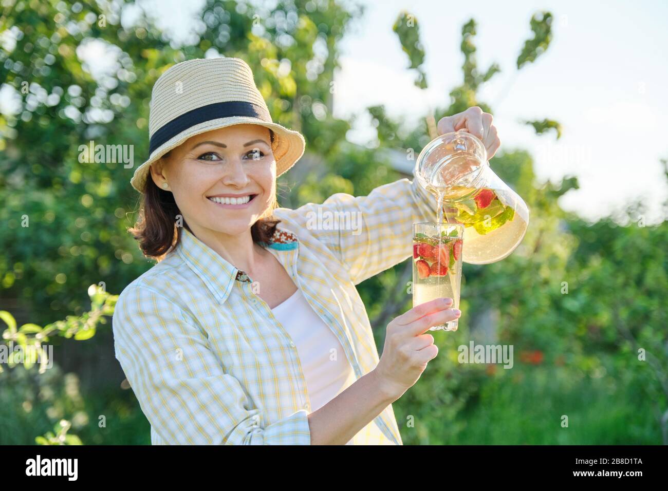 Rinfreschi estivi di primavera, donna in natura che tiene vasetto di menta e limone, bevande rinfrescanti fredde, bevande sane vitamine fatte in casa Foto Stock