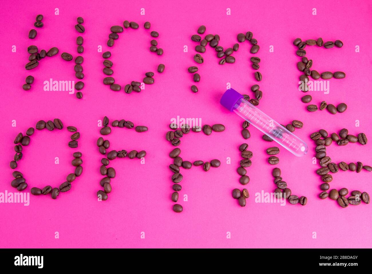 Home Office fatto di chicchi di caffè disposti su uno sfondo rosa Foto Stock