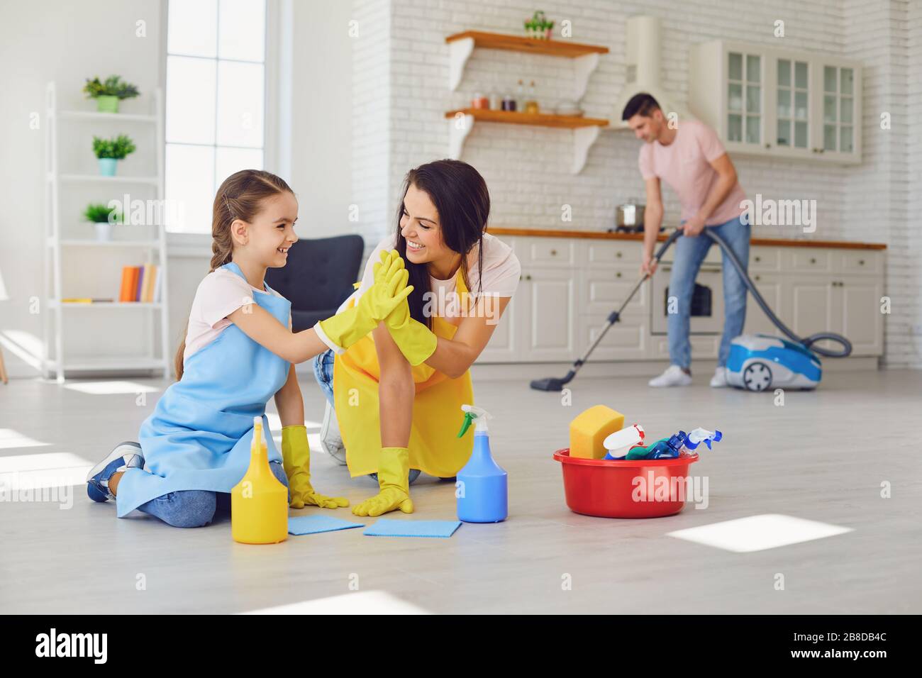 Happy Family pulisce la stanza con i guanti. Madre, figlio e figlia stanno  pulendo la casa Foto stock - Alamy