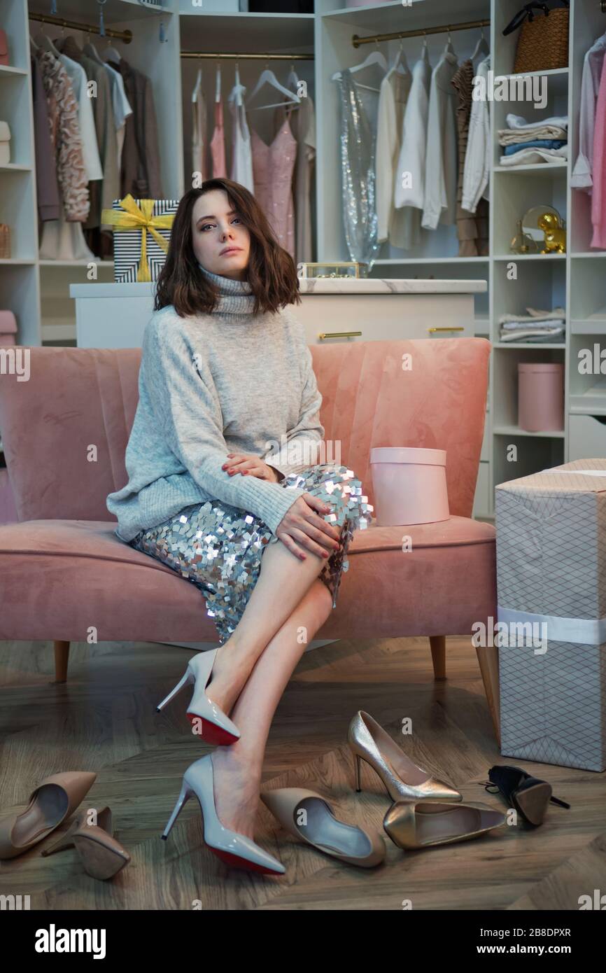 Giovane ragazza bella pensiva scelta di scarpe da armadio grande con abiti  eleganti, scarpe e roba casa. Concetto niente da indossare. Scelta di scarpe  per occasioni speciali Foto stock - Alamy