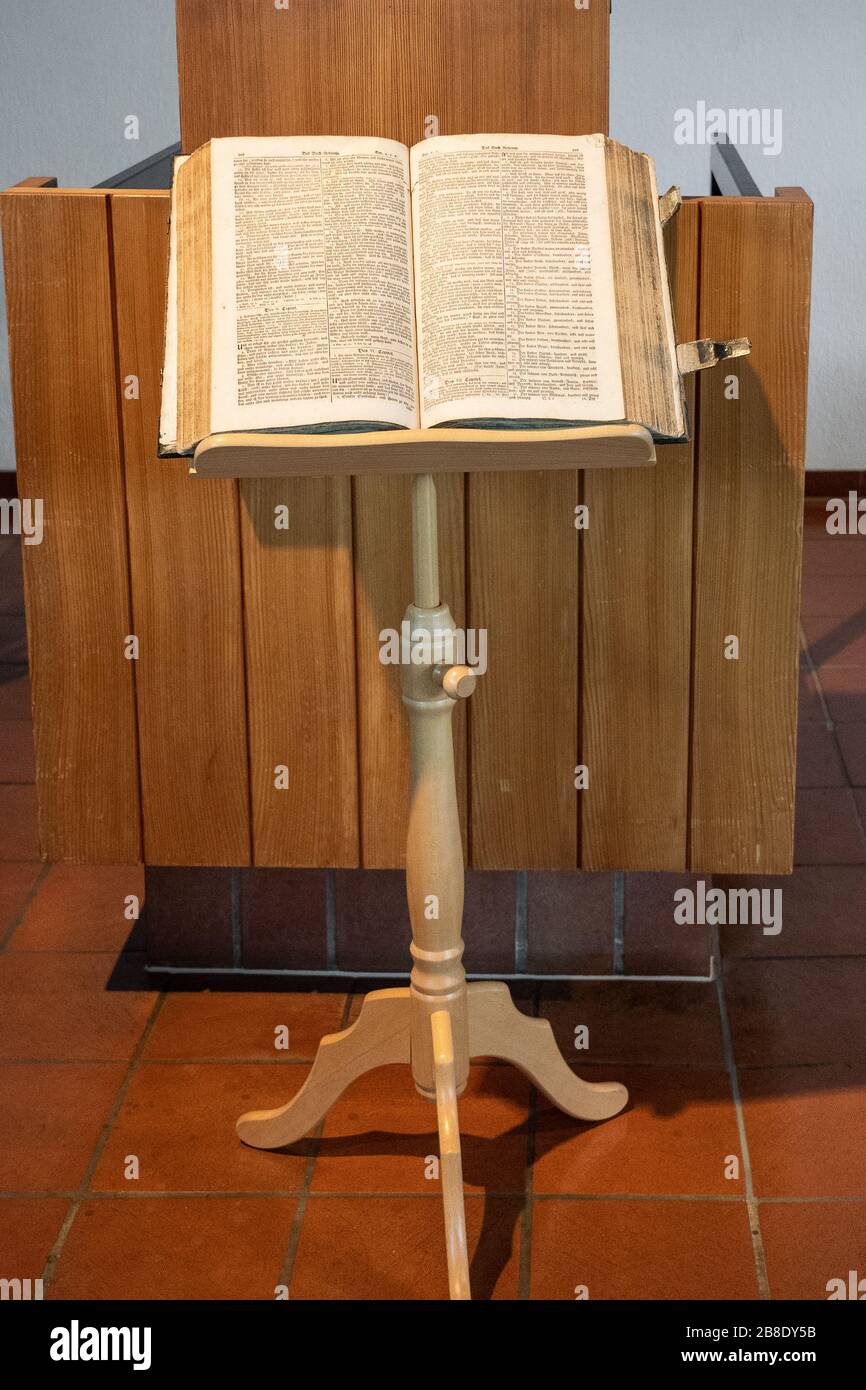 Aprire la bibbia su un libro stand nella chiesa svizzera di riforma. Pubblicazione, riforma, carta, interni, tradizione, icone religiose, libertà, concetto. Foto Stock