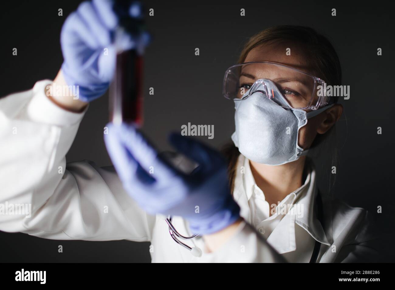 Medico femmina che contiene un flacone di vetro con un campione di sangue Foto Stock