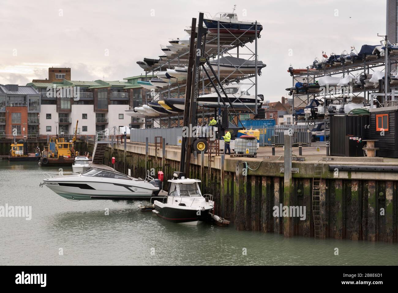 Vista delle scaffalature di deposito della barca e di una barca che è sollevata dall'acqua al molo di Camber, Portsmouth, Regno Unito Foto Stock