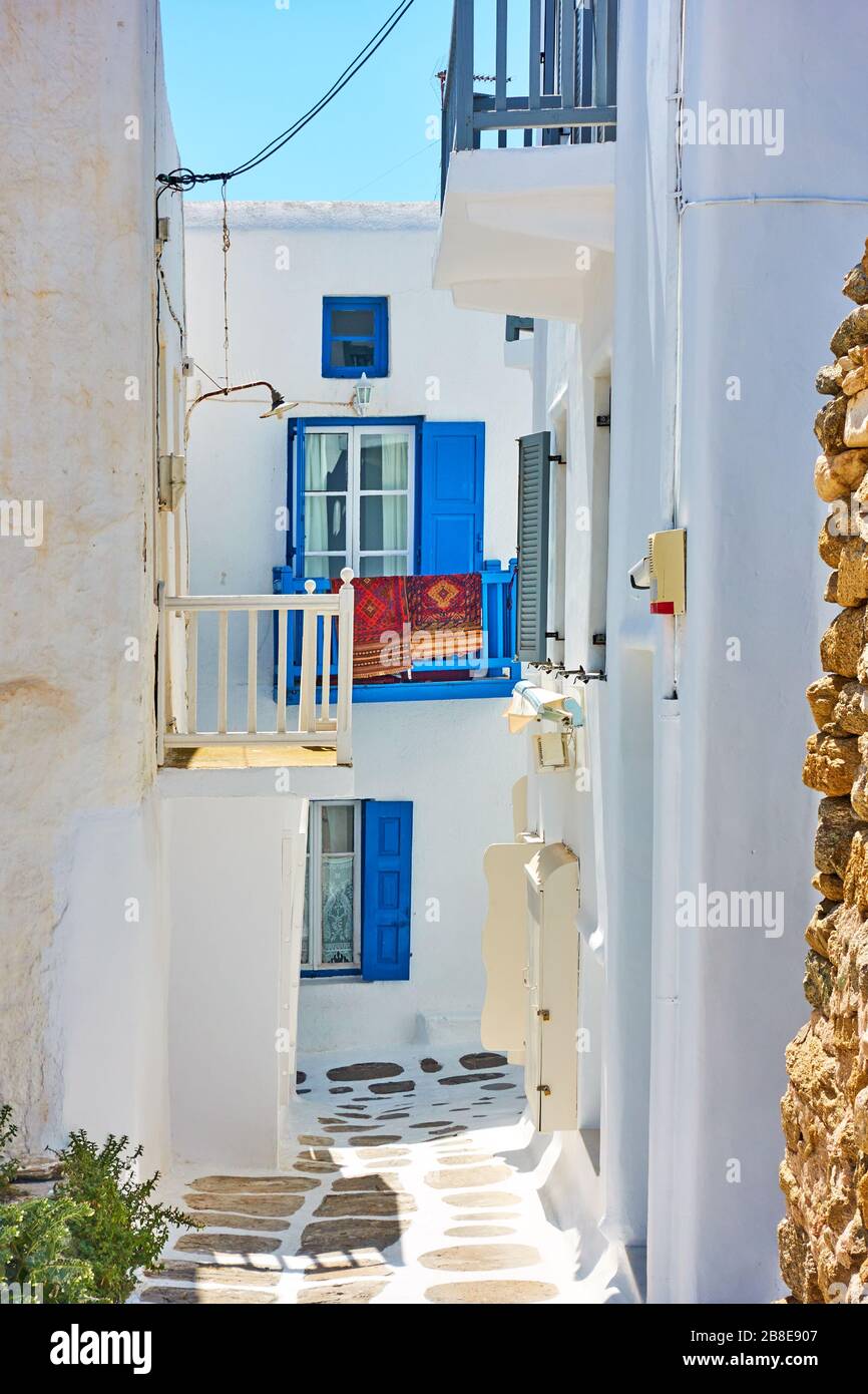 Strada stretta con piccole case bianche con balconi a Mykonos, Grecia. Paesaggio urbano greco Foto Stock