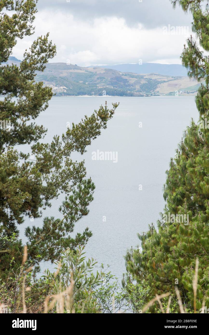 Lago Tota, Boyaca / Colombia: 7 aprile 2018: Il più grande lago colombiano visto attraverso un paio di alberi Foto Stock