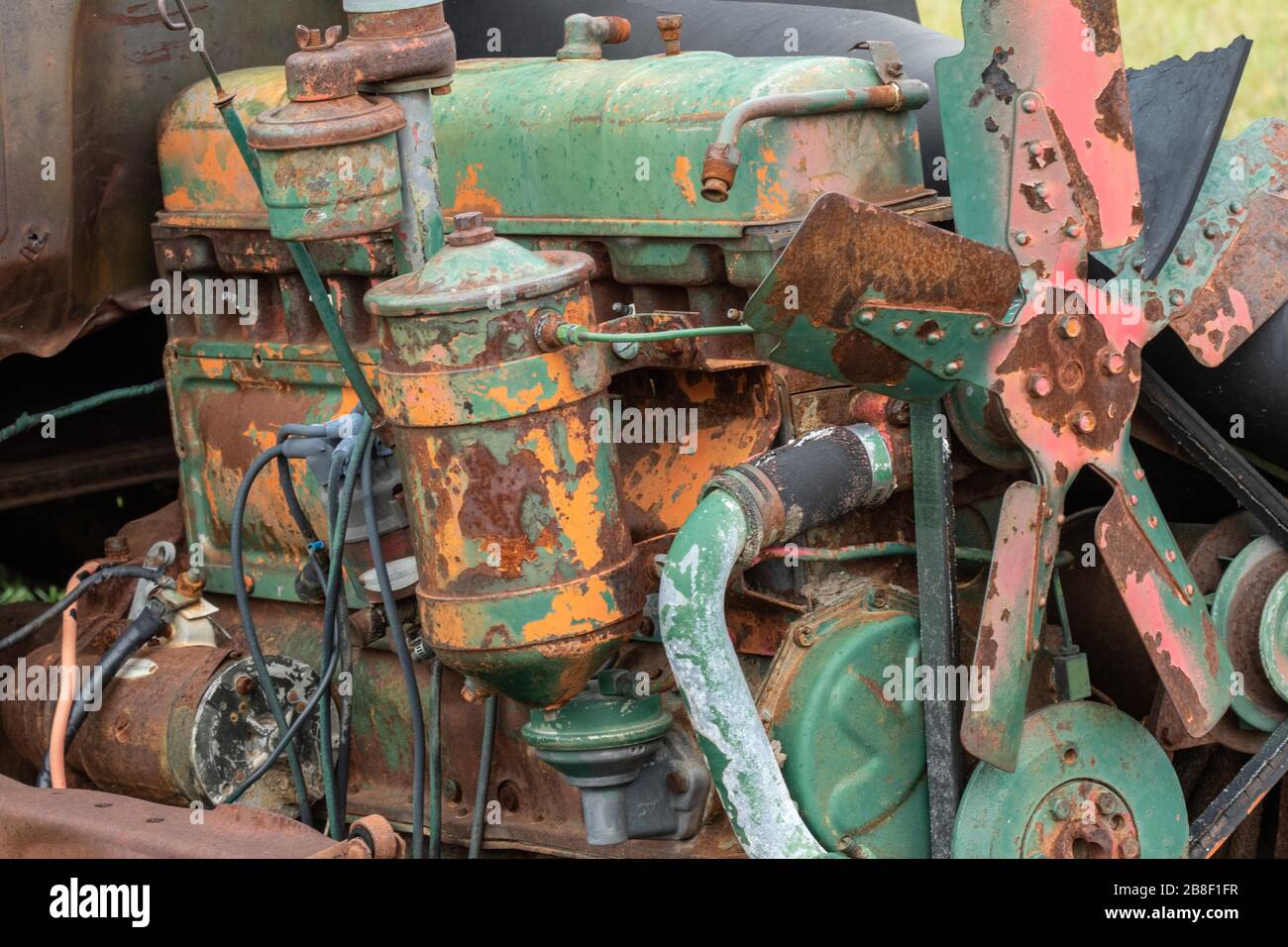 Vecchio motore in un'automobile junked, verniciato sopra Foto Stock