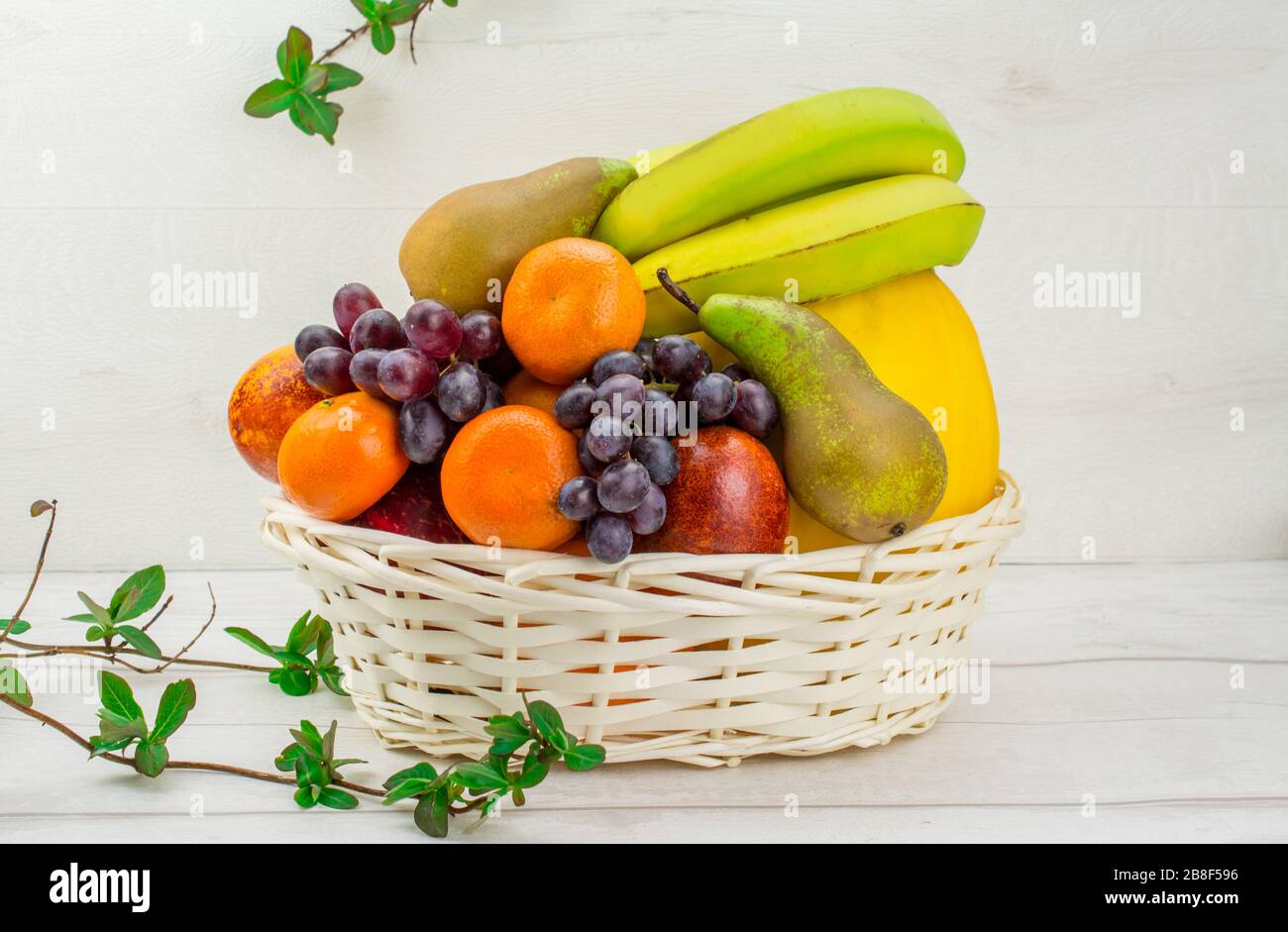 cesto di frutta su fondo bianco pere melone, arance , uva , mela , mandarino Foto Stock