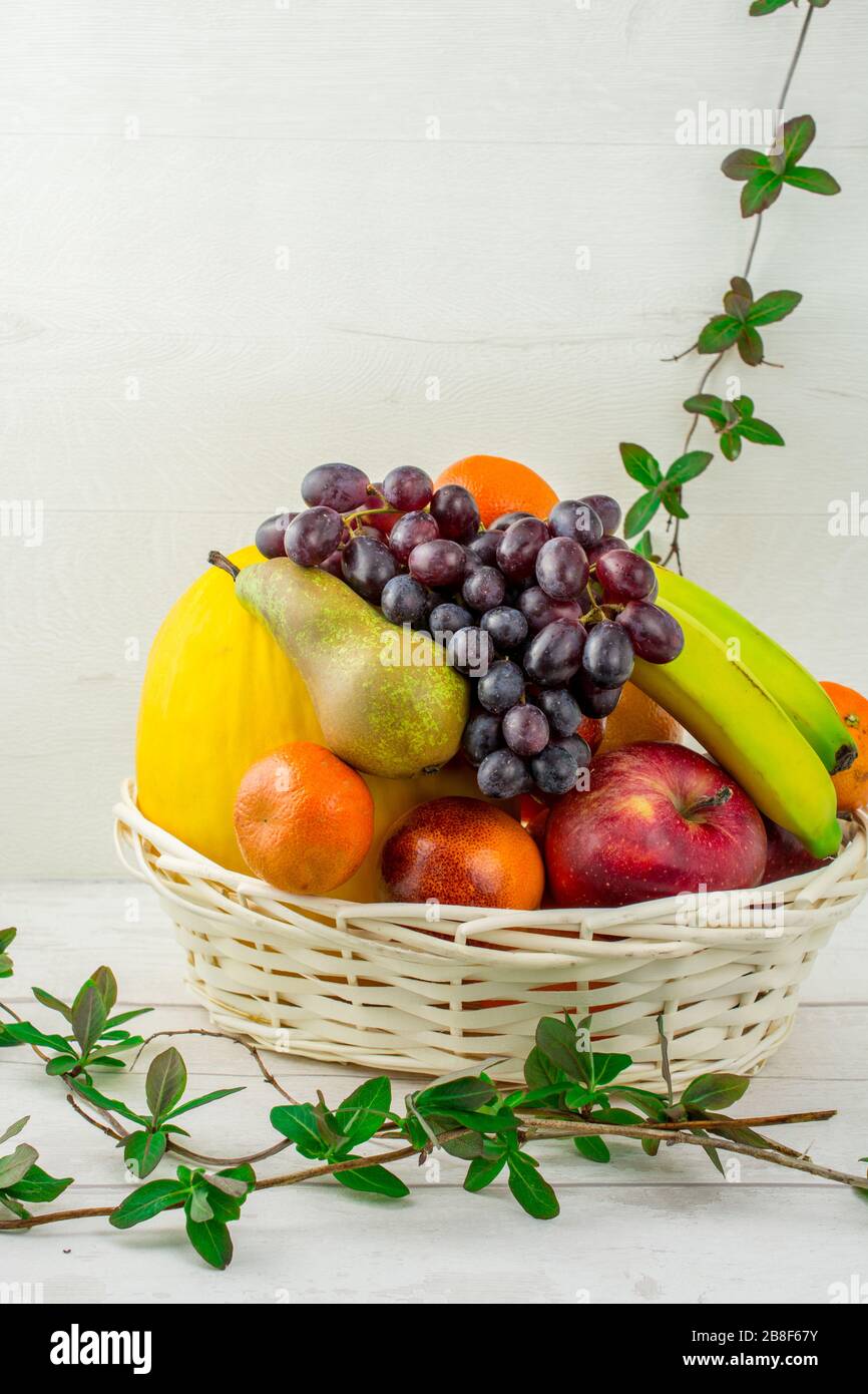 cesto di frutta su fondo bianco pere melone, arance , uva , mela , mandarino Foto Stock