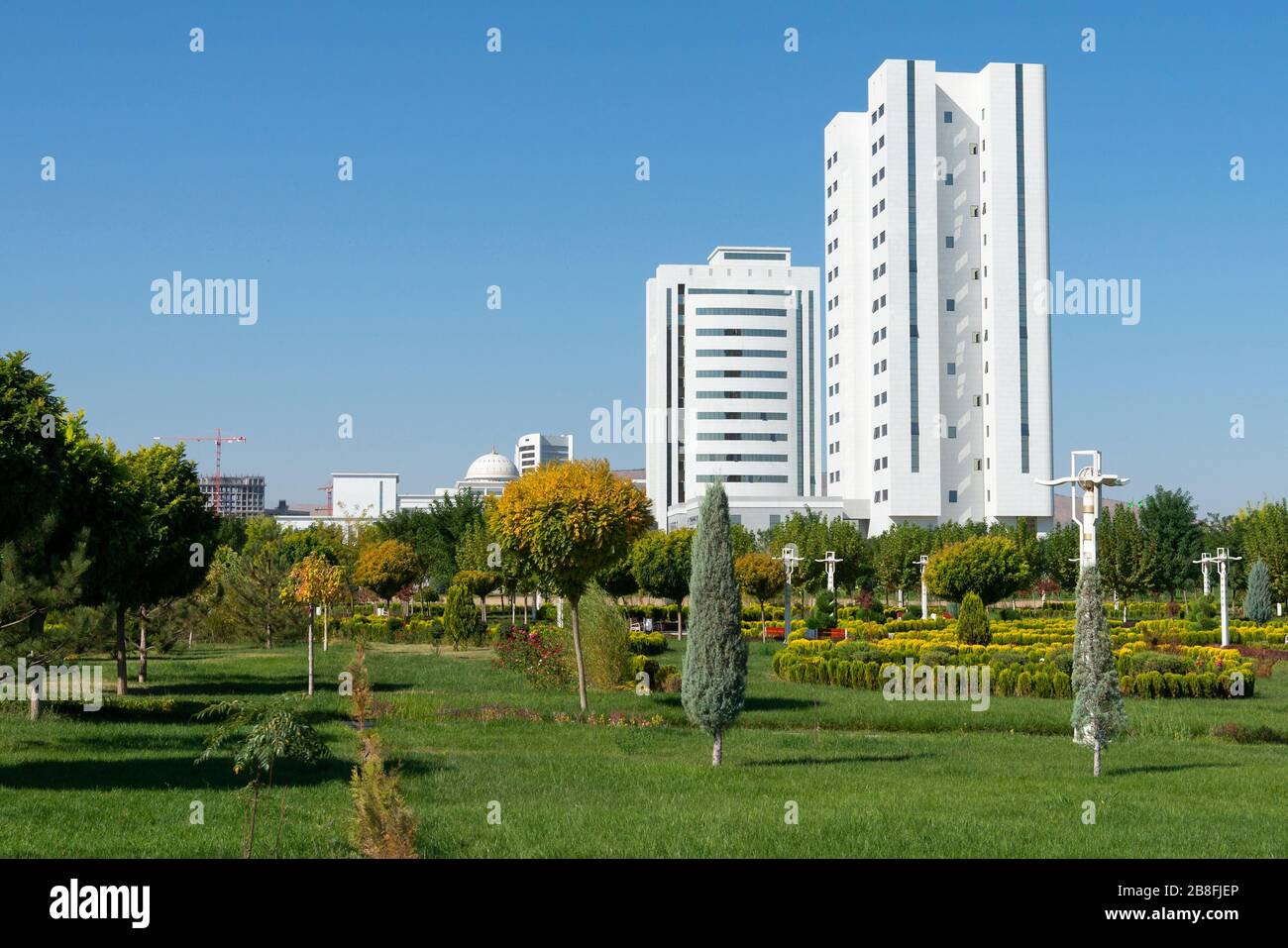 Parco con splendido giardino e vegetazione ad Ashgabat, Turkmenistan. Città in marmo bianco. Uffici governativi turkmen. Foto Stock