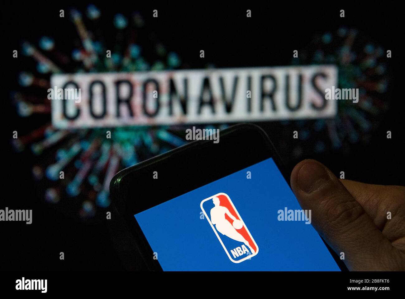 In questa illustrazione della foto il logo della lega di pallacanestro professionale maschile dell'American National Basketball Association (NBA) visualizzato su uno smartphone con un modello di computer del coronavirus COVID-19 sullo sfondo. Foto Stock
