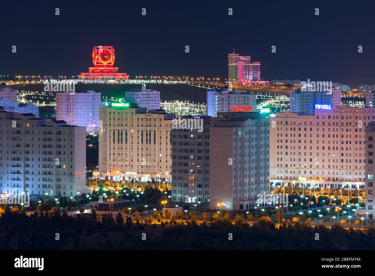 Ashgabat, skyline del Turkmenistan di notte. Wedding Palace, un edificio del registro civile e Ashgabat Hotel visibile. Numerosi edifici in marmo bianco. Foto Stock