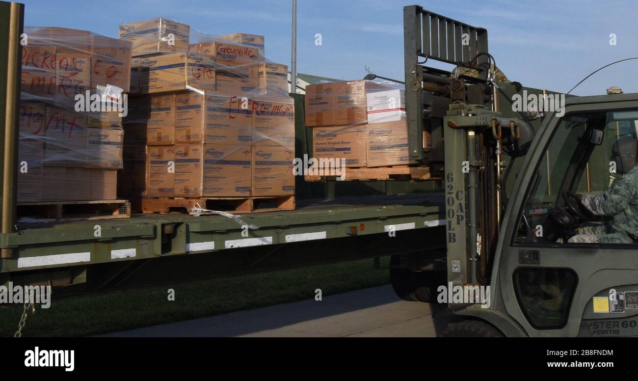 Soldati della Guardia Nazionale dell'Esercito degli Stati Uniti con il comando della 5nona truppa, Guardia Nazionale della Carolina del Sud, E gli Airmen della Guardia Nazionale dell'aria degli Stati Uniti con il Squadron di preparazione di logistica 169th, la Guardia Nazionale del Carolina del Sud, carica i dispositivi di protezione personali ed altri rifornimenti 20 marzo 2020 per essere trasportato e distribuito alle 46 contee nel Carolina del Sud in sostegno del reparto del Carolina del Sud di salute e controllo ambientale. La Guardia Nazionale della Carolina del Sud rimane pronta a sostenere le contee, le agenzie locali e statali e i soccorritori con le risorse richieste per tutto il tempo necessario in sup Foto Stock
