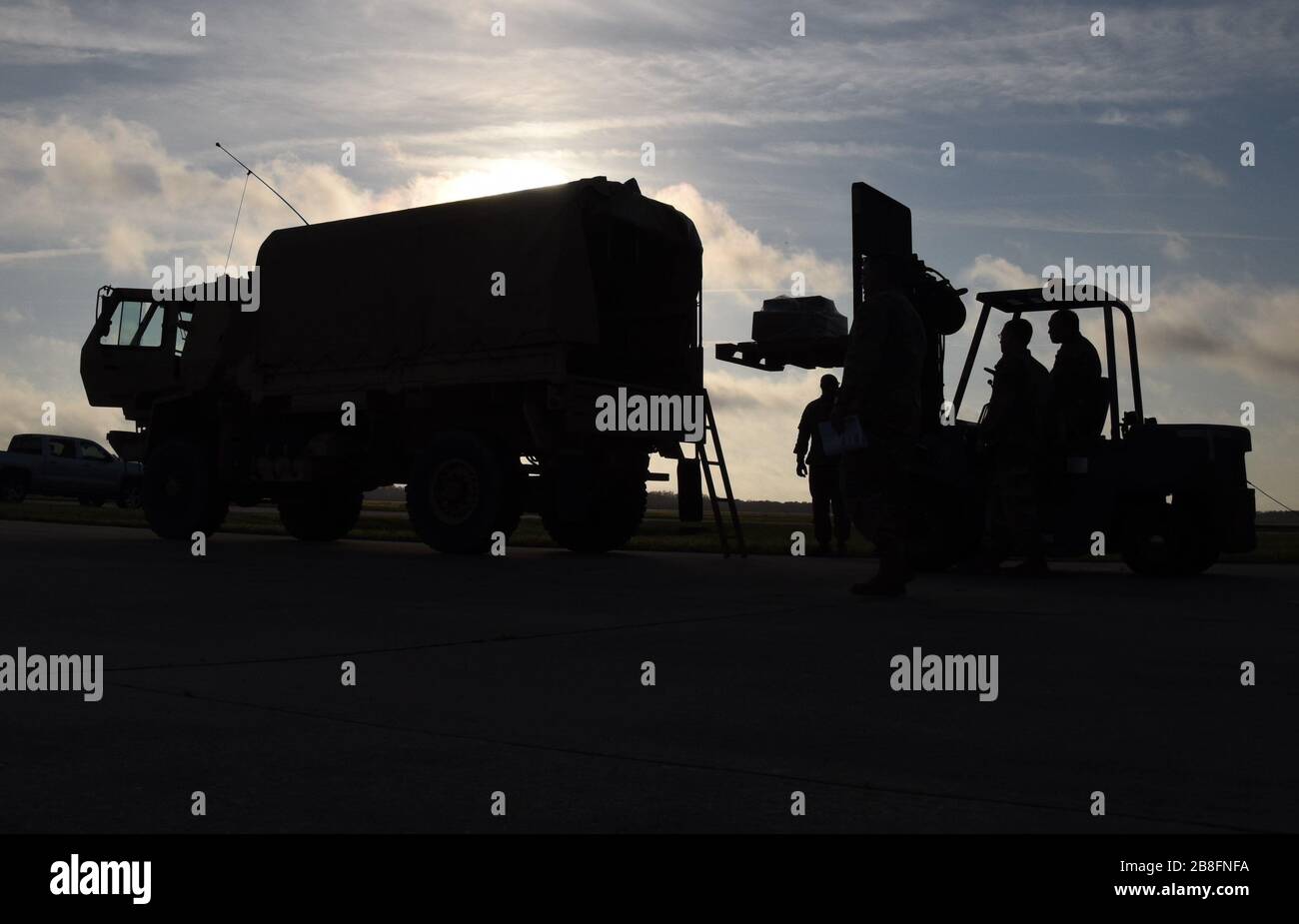 Soldati della Guardia Nazionale dell'Esercito degli Stati Uniti con il comando della 5nona truppa, Guardia Nazionale della Carolina del Sud, E gli Airmen della Guardia Nazionale dell'aria degli Stati Uniti con il Squadron di preparazione di logistica 169th, la Guardia Nazionale del Carolina del Sud, carica i dispositivi di protezione personali ed altri rifornimenti 20 marzo 2020 per essere trasportato e distribuito alle 46 contee nel Carolina del Sud in sostegno del reparto del Carolina del Sud di salute e controllo ambientale. La Guardia Nazionale della Carolina del Sud rimane pronta a sostenere le contee, le agenzie locali e statali e i soccorritori con le risorse richieste per tutto il tempo necessario in sup Foto Stock