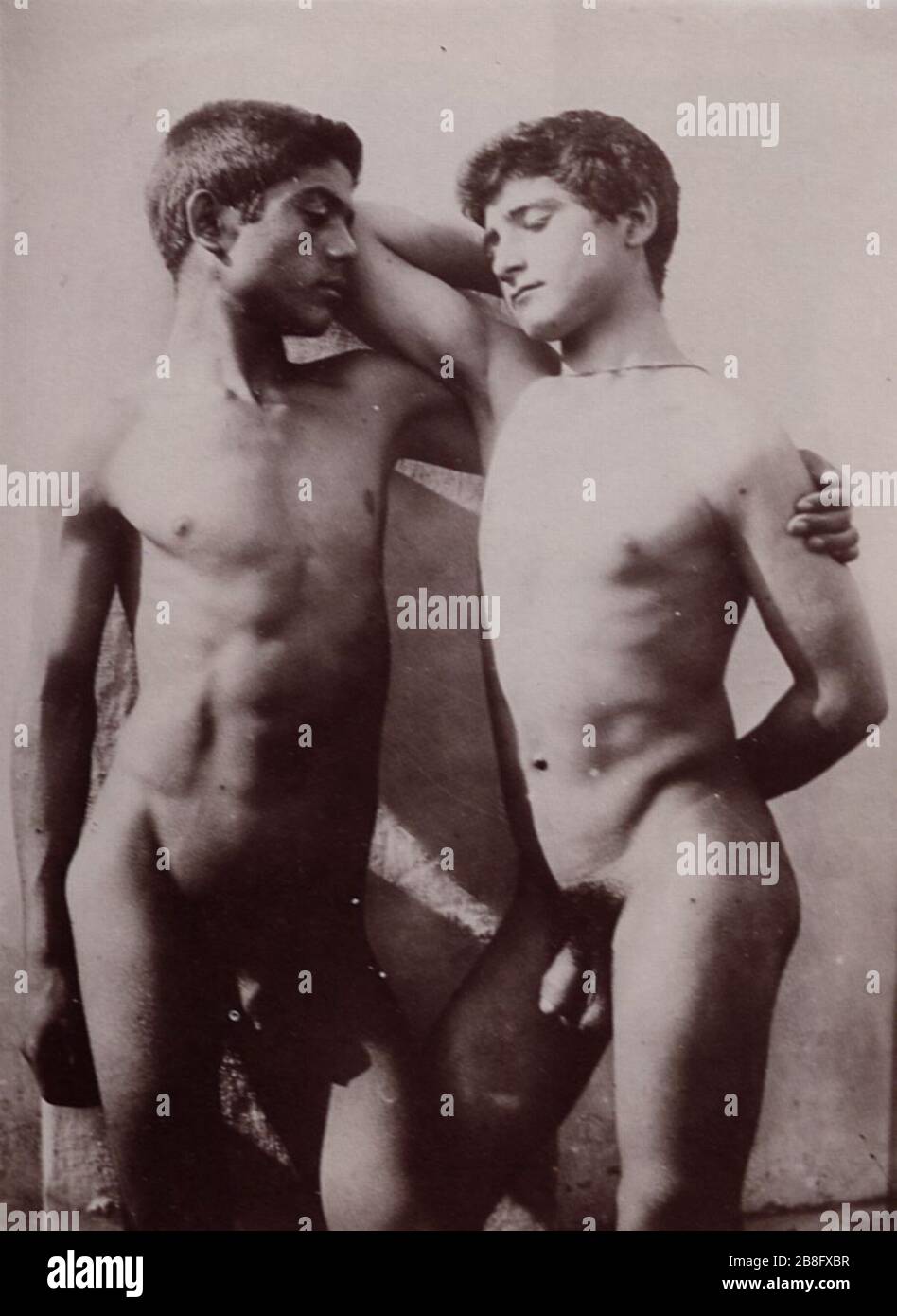 Gloeden, Wilhelm von - Zwei sich vor einer weißen Wand umarmende Freunde Foto Stock