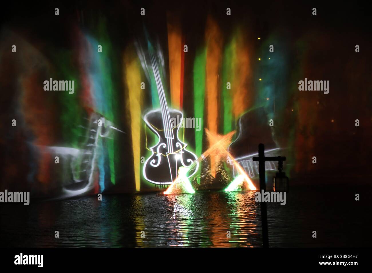 Luci colorate sull'acqua nel parco a tema di notte e altri oggetti per l'intrattenimento di ospiti paganti in Anaheim California colore concetti sfondi Foto Stock