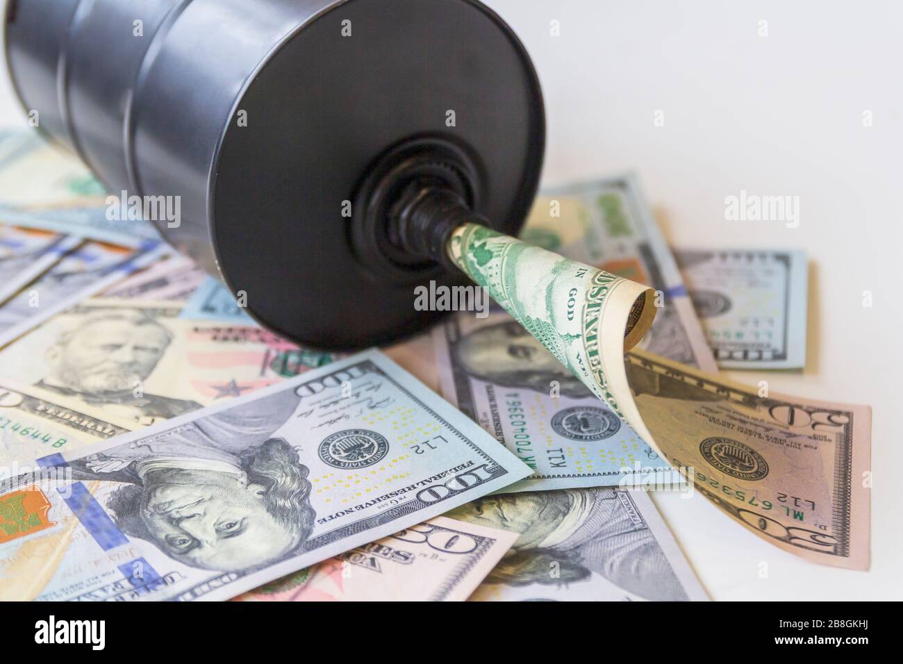 Barile di petrolio su uno sfondo, dollari americani background. Trend in calo della diminuzione dei prezzi al barile degli utili e dell'economia globale . Messa a fuoco selettiva. Foto Stock