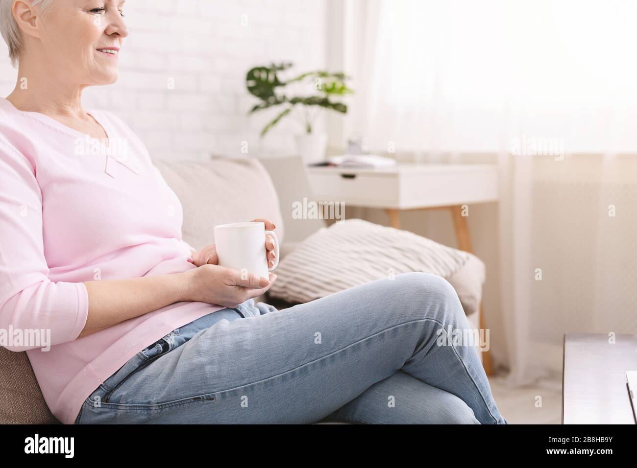 La signora senior si gustava un caffè caldo e fresco nel soggiorno Foto Stock