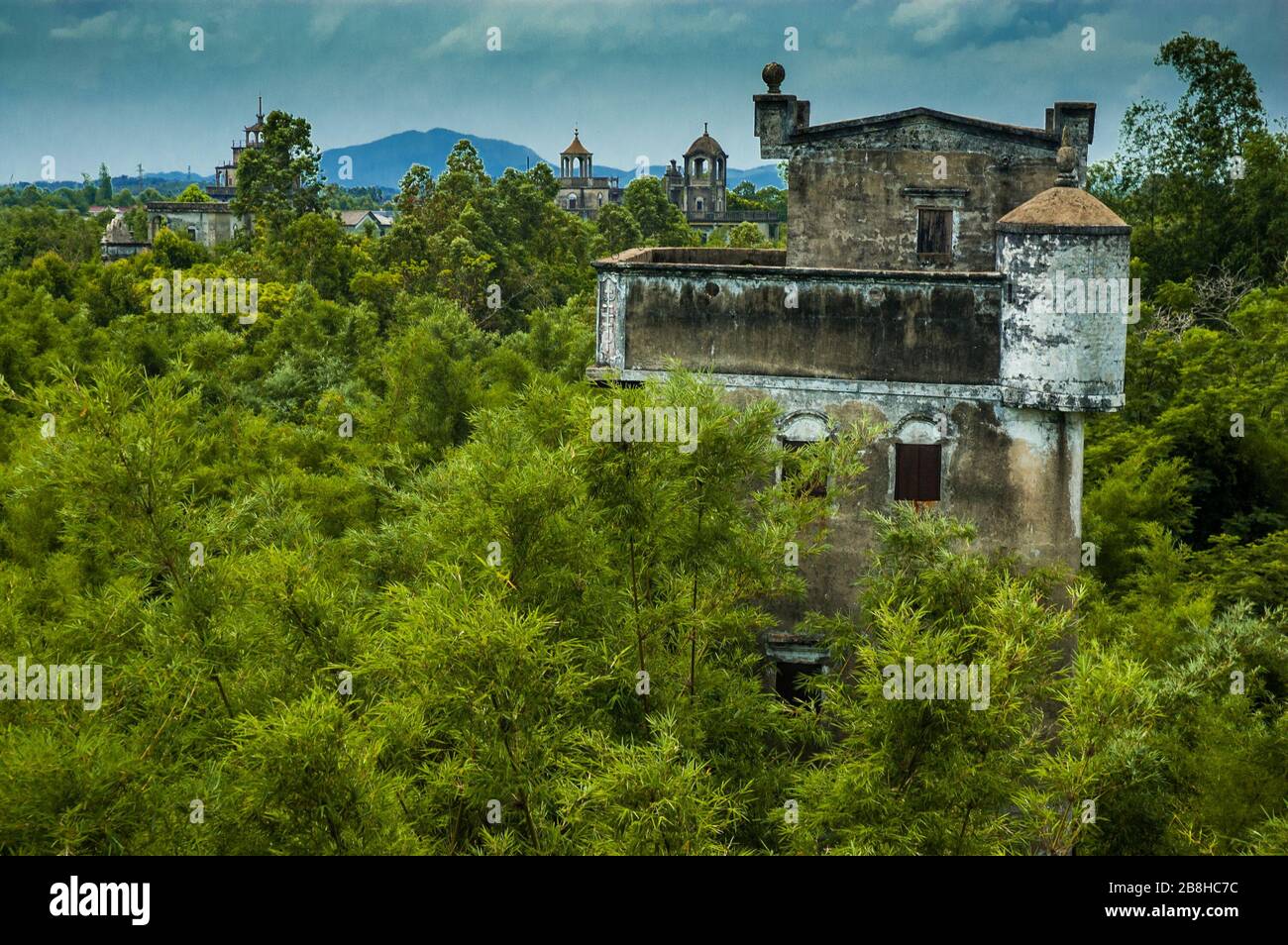 Le cime di diaolou poke fuori dalla cornice piante di bambù e alberi a Majianglong village, del Kaiping. Foto Stock