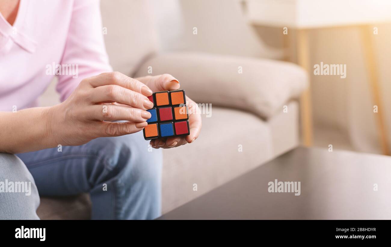 Cubo di Rubik in mani di donna matura Foto Stock